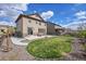 Backyard with landscaped beds, wood fence and patio with adjacent grass area at 7763 S Elk St, Aurora, CO 80016