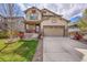 Charming two-story home with a covered front porch, beautiful lawn, and a two-car garage at 7763 S Elk St, Aurora, CO 80016