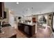 Open kitchen with island and stainless steel appliances, flowing into the living and dining areas at 7763 S Elk St, Aurora, CO 80016