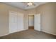 Neutral bedroom featuring carpet, ceiling fan, and double-door closet with additional closet in hall at 1343 Villa Grv, Monument, CO 80132