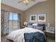 Cozy bedroom featuring floral curtains, large window, ceiling fan, and mountain landscape pictures at 1343 Villa Grv, Monument, CO 80132