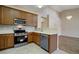 Kitchen features stainless steel appliances, wood cabinets, and tile flooring at 1343 Villa Grv, Monument, CO 80132