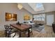 Bright living room featuring hardwood floors, skylight, dining area, and stylish contemporary furnishings at 1343 Villa Grv, Monument, CO 80132