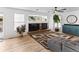 Cozy living room with a fireplace, a large TV, hardwood floors, and stylish decor at 2468 Candleglow St, Castle Rock, CO 80109