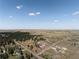 Expansive aerial view of a home with surrounding land, trees, and a vast open landscape under a clear blue sky at 5917 Black Forest Dr, Elizabeth, CO 80107