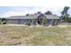 Rear exterior view features a large gray home with a patio, landscaping, and a grassy yard at 5917 Black Forest Dr, Elizabeth, CO 80107
