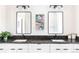 Modern bathroom vanity featuring double sinks, dark countertops, and sleek black hardware at 5917 Black Forest Dr, Elizabeth, CO 80107