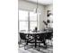 Dining room with large window and a round table set for six, illuminated by pendant lighting at 5917 Black Forest Dr, Elizabeth, CO 80107