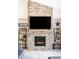 Elegant floor-to-ceiling stone fireplace with a mounted TV, offering a cozy and stylish focal point at 5917 Black Forest Dr, Elizabeth, CO 80107