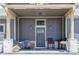 Inviting front porch with stone pillars, outdoor seating, decorative plants, and a stylish front door at 5917 Black Forest Dr, Elizabeth, CO 80107
