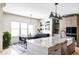 Open kitchen and dining area with a large island, pendant lights, and modern appliances at 5917 Black Forest Dr, Elizabeth, CO 80107
