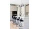 Kitchen island featuring quartz countertops, bar stool seating, designer lighting, and elegant cabinetry at 5917 Black Forest Dr, Elizabeth, CO 80107