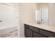Bright bathroom featuring a large mirror, modern vanity with dark cabinets, and a shower-tub combination at 1961 S Haleyville Way, Aurora, CO 80018