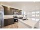 Well-lit kitchen with stainless steel appliances, modern dark cabinetry, and a center island with quartz countertops at 1961 S Haleyville Way, Aurora, CO 80018