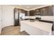 Modern kitchen features stainless steel appliances, dark wood cabinets, and a white countertop island for food preparation at 1961 S Haleyville Way, Aurora, CO 80018