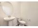 Clean powder room featuring a pedestal sink, oval mirror, and modern fixtures, ideal for guests at 1961 S Haleyville Way, Aurora, CO 80018