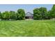 Beautiful backyard with well manicured lawn, mature trees and home in the background at 7126 E 162Nd Ct, Brighton, CO 80602