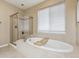 Bright bathroom showcasing soaking tub and a glass enclosed shower at 7126 E 162Nd Ct, Brighton, CO 80602