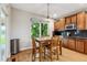 Dining area with wood table, chairs, wood floors, stainless steel trash can, and a window overlooking backyard at 7126 E 162Nd Ct, Brighton, CO 80602