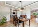 Elegant dining area with hardwood floors, modern light fixture, and open access to adjacent living spaces at 7126 E 162Nd Ct, Brighton, CO 80602