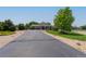 Long paved driveway leading to a well-maintained home with mature trees and landscaping at 7126 E 162Nd Ct, Brighton, CO 80602