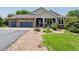 Charming home featuring a stone facade, covered porch, and well-maintained gravel and grass landscaping at 7126 E 162Nd Ct, Brighton, CO 80602