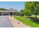 Beautifully landscaped front yard with mature trees and gravel accents leading up to a well-maintained home at 7126 E 162Nd Ct, Brighton, CO 80602