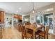 Kitchen with wood cabinets, wood floors, stainless appliances, island, and a view to the breakfast nook at 7126 E 162Nd Ct, Brighton, CO 80602