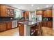Kitchen features stainless steel appliances, wood cabinets, granite counters, hardwood floors, and an island with seating at 7126 E 162Nd Ct, Brighton, CO 80602