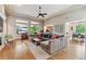 Open concept living room with hardwood floors, large windows, and comfortable seating at 7126 E 162Nd Ct, Brighton, CO 80602