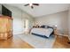 Main bedroom with ensuite bath, wood floors, ceiling fan, and traditional decor at 7126 E 162Nd Ct, Brighton, CO 80602