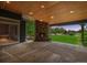 Covered patio featuring a stone fireplace and views of the beautiful backyard at 7126 E 162Nd Ct, Brighton, CO 80602
