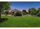 Expansive green yard with beautiful landscaping and a white fence, perfect for outdoor activities at 7126 E 162Nd Ct, Brighton, CO 80602
