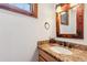Charming half-bath with granite countertop and rustic mirror at 1152 Ski Hill Rd, Breckenridge, CO 80424