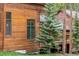 Rustic wood cabin exterior with green-trimmed windows and natural landscaping at 1152 Ski Hill Rd, Breckenridge, CO 80424