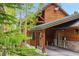 Rustic wood cabin boasts a covered carport, natural stone accents, and a picturesque surrounding landscape at 1152 Ski Hill Rd, Breckenridge, CO 80424