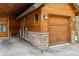 Close-up exterior shot of the garage and covered parking area with stone detail at 1152 Ski Hill Rd, Breckenridge, CO 80424