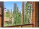 Scenic view from the balcony showcasing towering trees, a building, and clear blue skies at 1152 Ski Hill Rd, Breckenridge, CO 80424