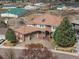 Aerial view of a spacious home with a tile roof, a three-car garage, and a circular driveway surrounded by lush landscaping at 132 Loveland Way, Golden, CO 80401