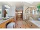 Bright bathroom with a soaking tub, glass shower, and vanity with dual sinks at 132 Loveland Way, Golden, CO 80401