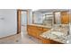 Bright bathroom featuring dual sinks, wooden cabinetry, granite counters, and a shower at 132 Loveland Way, Golden, CO 80401