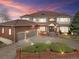 Stunning two-story brick home featuring a three-car garage, landscaped front yard, and steps leading up to a covered entryway at 132 Loveland Way, Golden, CO 80401