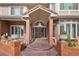 Elegant front entrance with double doors, a covered porch, and decorative planters on brick pillars at 132 Loveland Way, Golden, CO 80401