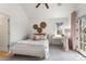 Bright bedroom with a large window, ceiling fan, light walls, and neutral decor with a charming desk at 2486 S Monroe St. St, Denver, CO 80210