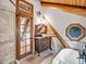 Rustic bathroom featuring vanity, a clawfoot tub, and a glass-enclosed wood door at 1000 Lodgepole Dr, Evergreen, CO 80439