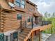 Beautiful log home with spacious deck, stairs, a DirectTV satellite, and lush trees at 1000 Lodgepole Dr, Evergreen, CO 80439