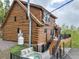 Charming log home with hot tub, deck, stairs, and lush greenery around the perimeter at 1000 Lodgepole Dr, Evergreen, CO 80439