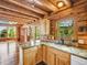 Kitchen area boasts light wood cabinets, stone countertops, and a view of the lush landscape at 1000 Lodgepole Dr, Evergreen, CO 80439