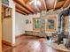 Cozy living space with hardwood floors, stone fireplace, wood beams and natural light at 1000 Lodgepole Dr, Evergreen, CO 80439