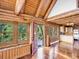 Inviting interior with log walls, vaulted ceilings, wood floors, large windows, and access to a deck at 1000 Lodgepole Dr, Evergreen, CO 80439